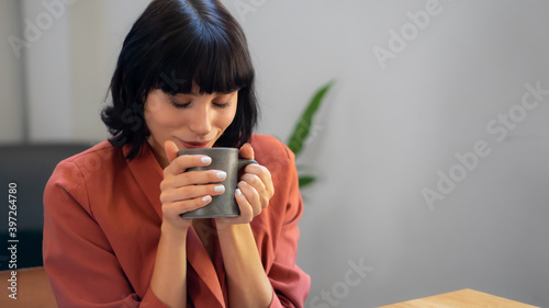 Close up portrait shot of relax beautiful caucasian lady holding cup.