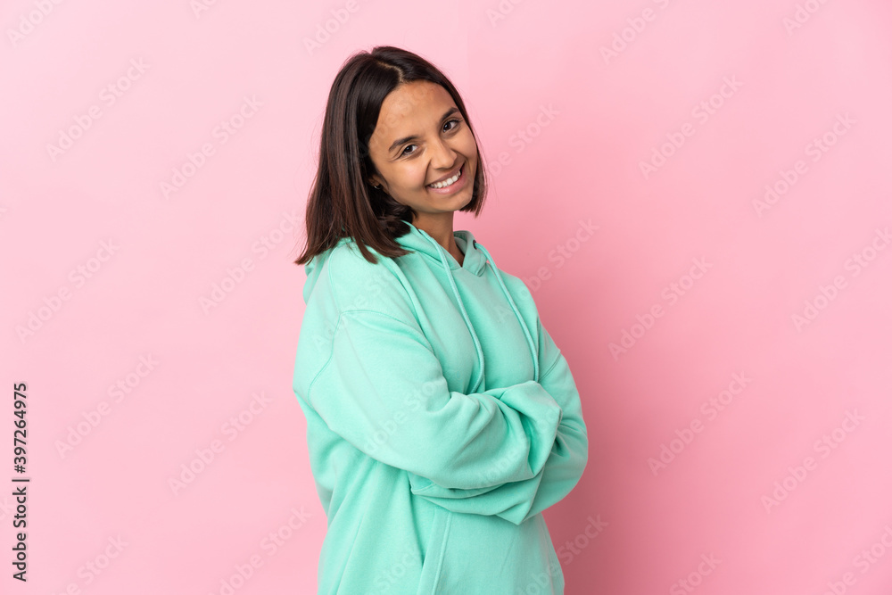 Young latin woman isolated on pink background with arms crossed and looking forward Young latin woman isolated on pink background with arms crossed and looking forward