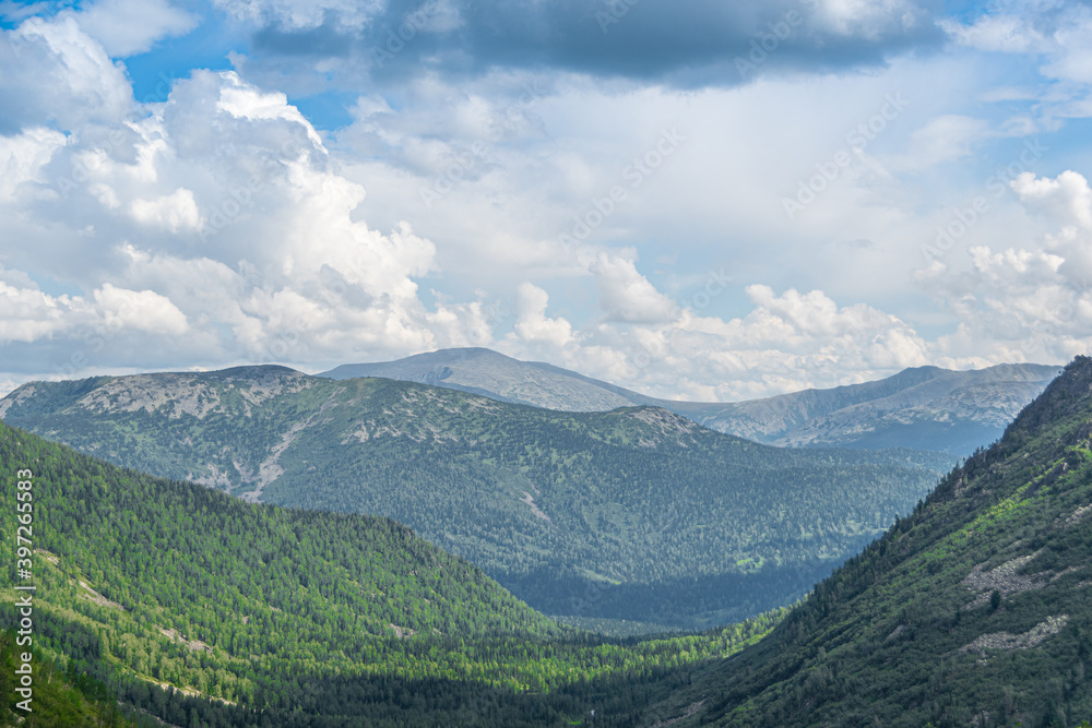 Rocky ridge on horizon under blue cloudy sky. Mountain valley for travel. Adventure travel, tourism and conservation concept. Rocky ridge on horizon under blue cloudy sky. Mountain valley for travel. Adventure travel, tourism and conservation concept.