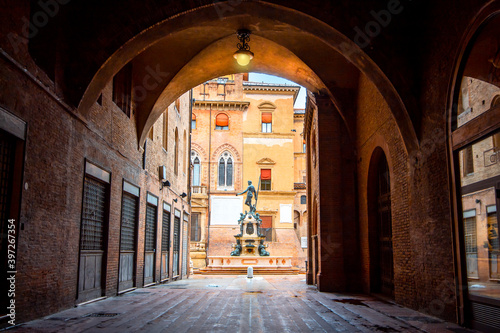 Neptune fountain Bologna, Italy - medieval bricks town with archs. Sunrise moment 
