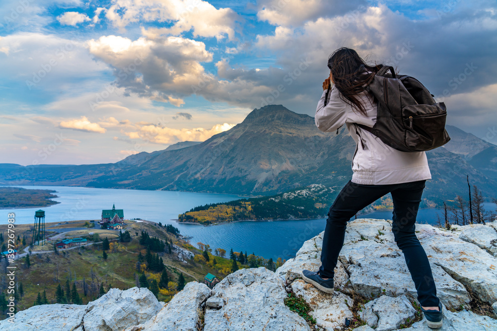 Naklejka premium Tourists taking pictures on Town of Waterton Lakes National Park in beautiful dusk. Landscape scenery in autumn foliage season. Alberta, Canada.