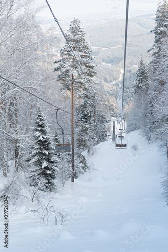 Chair lift in snowy winter landscap. Chairlift over frost forest