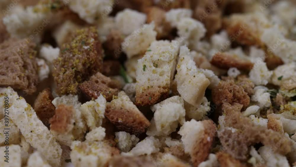 Close up view uncooked bread stuffing pieces with green herbs and yellow spices. Close up view uncooked bread stuffing pieces with green herbs and yellow spices.