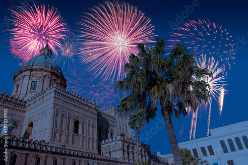 Celebratory fireworks for new year over Palermo Cathedral in Palermo, Italy during last night of year. Christmas blue atmosphere 