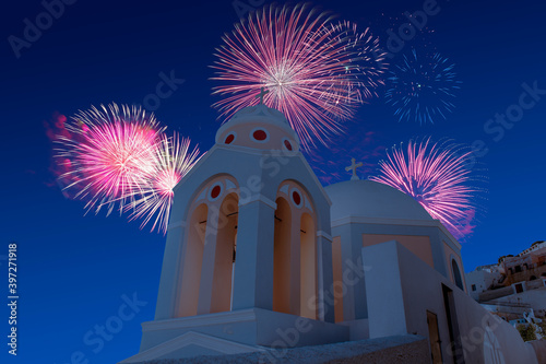 Celebratory fireworks for new year over orthodox white church in santorini during last night of year. Christmas atmosphere