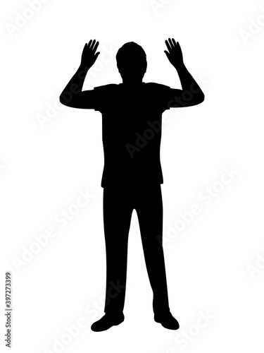 Silhouette of man surrenders with raised arms photo