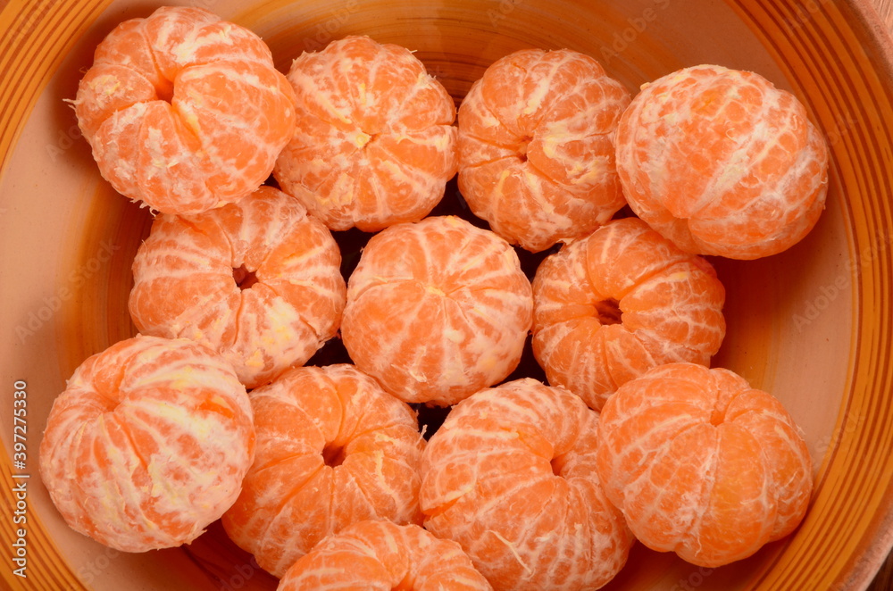 Freshly peeled tangerines in a clay bowl Freshly peeled tangerines in a clay bowl