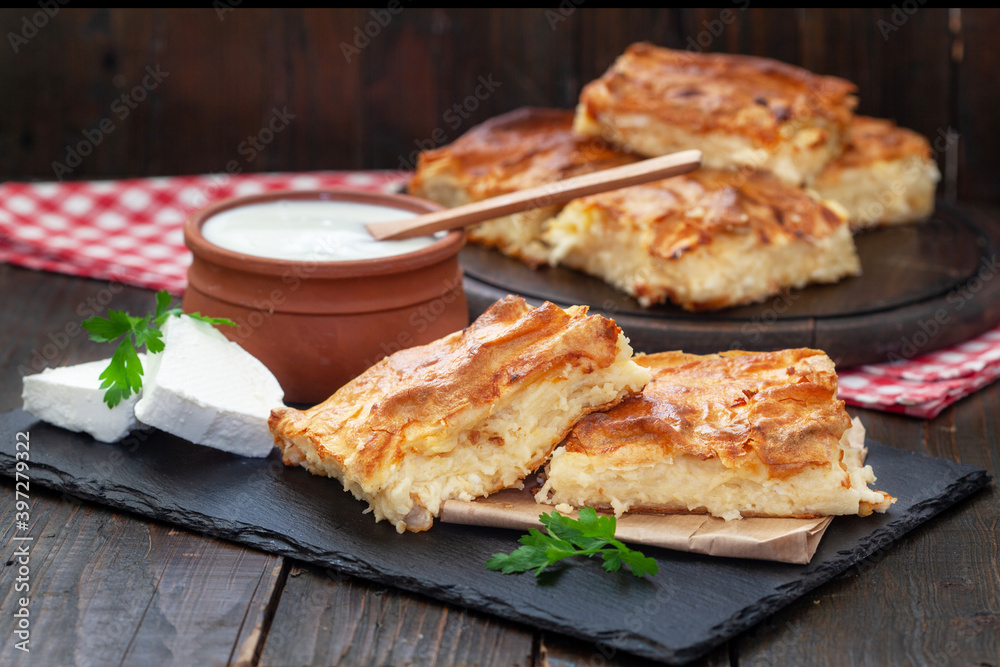 Homemade Traditional Serbian Gibanica with cheese. Delicious soft cheese pie, cut and layed on backing paper Homemade Traditional Serbian Gibanica with cheese. Delicious soft cheese pie, cut and layed on backing paper