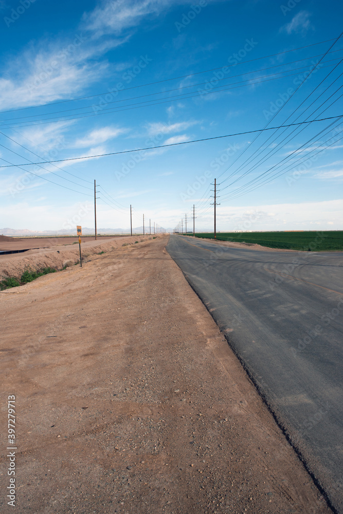 close-up of a road in the desert with power lines