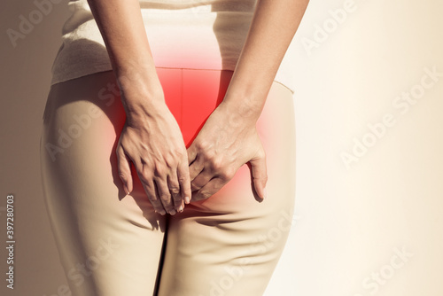 The pain caused by hemorrhoids. Woman suffering from hemorrhoid. Woman hands holding her butt because having pain. Health care concept.