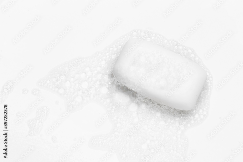 Soap bar and foam on white background