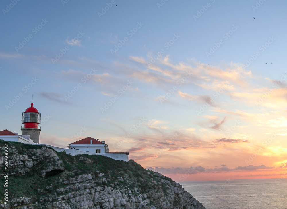 Seascape at sunset. Lighthouse on the coast.