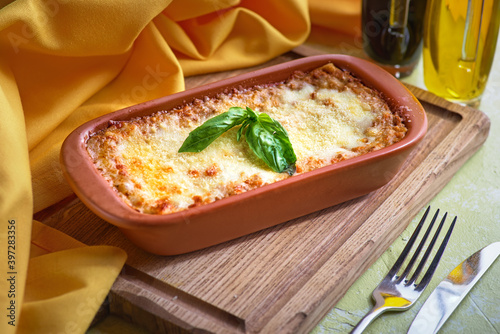 Traditional italian lasagna with vegetables, minced meat and cheese. On a wooden background. copy space