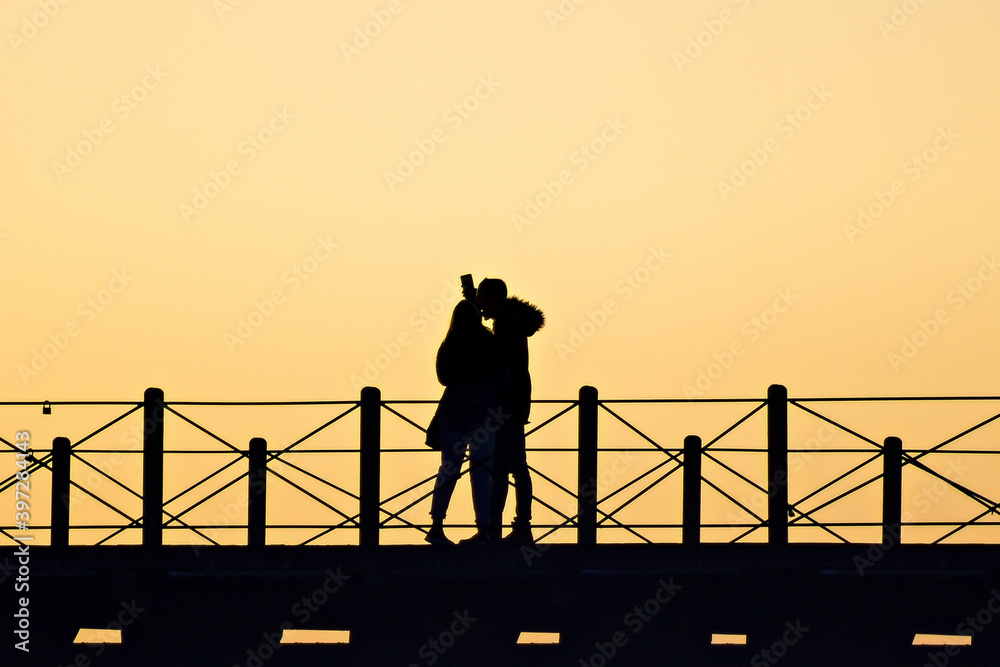silhouette of a couple taking a selfie in the Tinto Dock 
