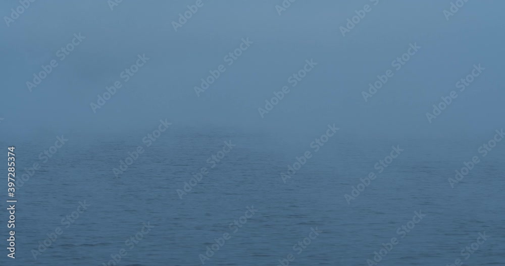 The cold weather is hitting the air over lake Mondsee during sunrise while mist is rising over the water, Mondsee, Austria The cold weather is hitting the air over lake Mondsee during sunrise while mist is rising over the water, Mondsee, Austria