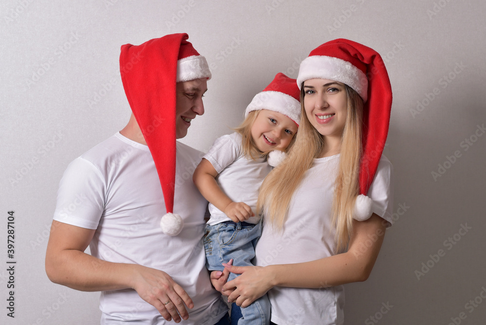 Obraz premium happy couple and baby in Christmas hats