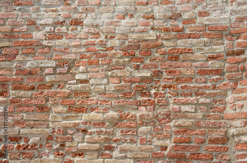 Old red grungy brick wall gives a harmonic structure