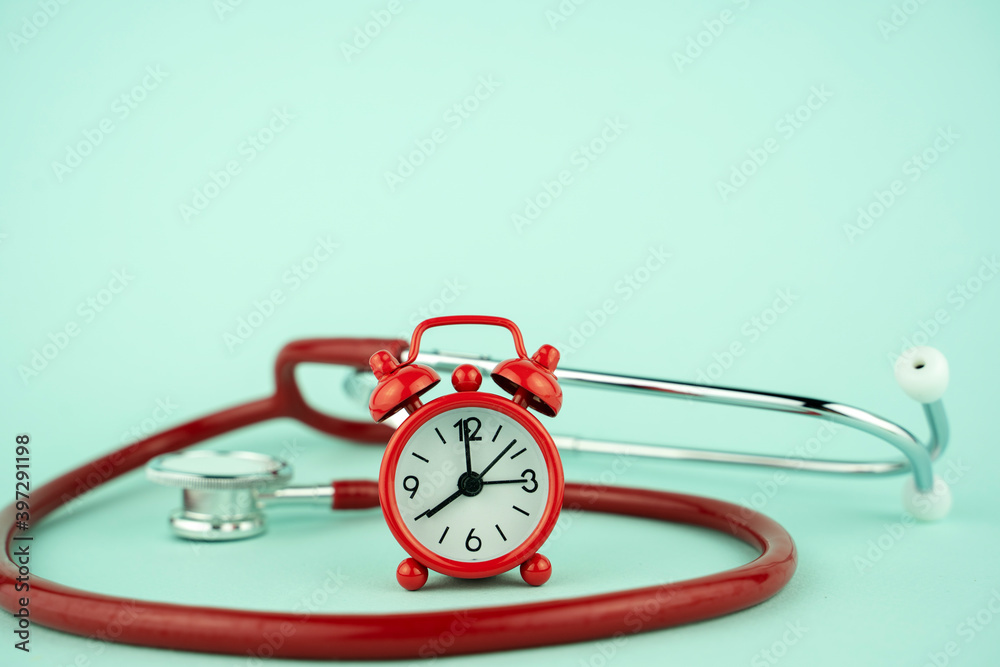 red alarm clock and stethoscope, treatment concept red alarm clock and stethoscope, treatment concept