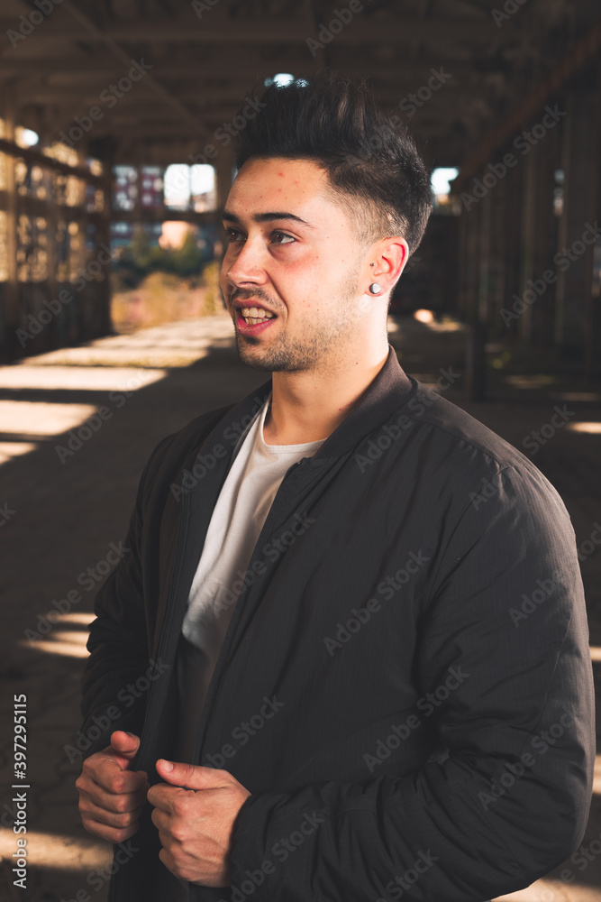 Fototapeta premium Young caucasian man posing in a abandoned pavilion.