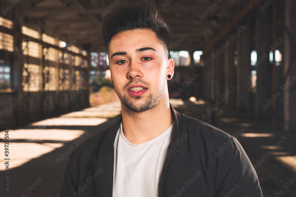 Young caucasian man posing in a abandoned pavilion.