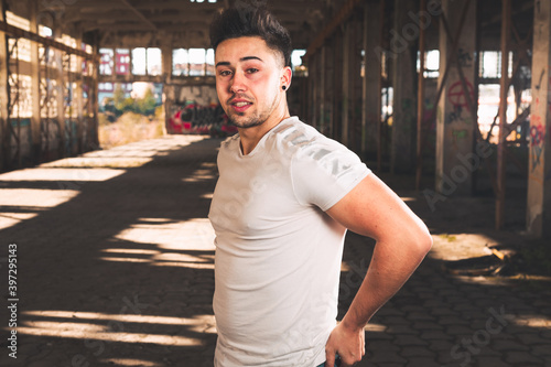 Young caucasian man posing in a abandoned pavilion.