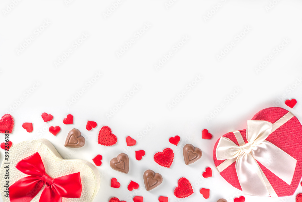 Red hearts, gift with ribbon and chocolates hearts flat lay, Valentine day and love background. Valentine's hearts ornament on white backdrop copy space top view Red hearts, gift with ribbon and chocolates hearts flat lay, Valentine day and love background. Valentine's hearts ornament on white backdrop copy space top view