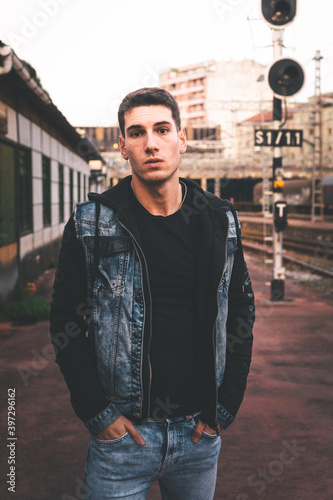 Young caucasian man posing in a train station.