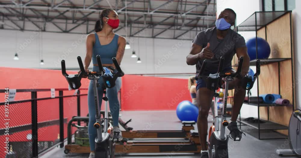 Man and woman wearing face masks touching elbows at gym Man and woman wearing face masks touching elbows at gym