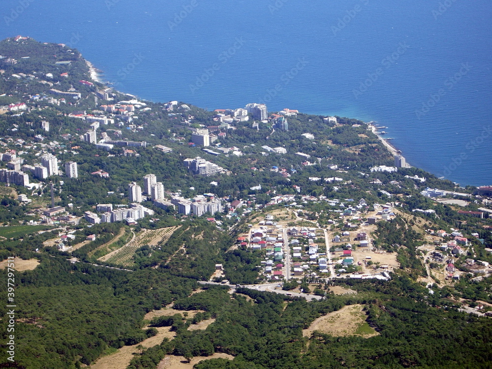 View of the seaside town and the endless blue sea from a very high altitude.