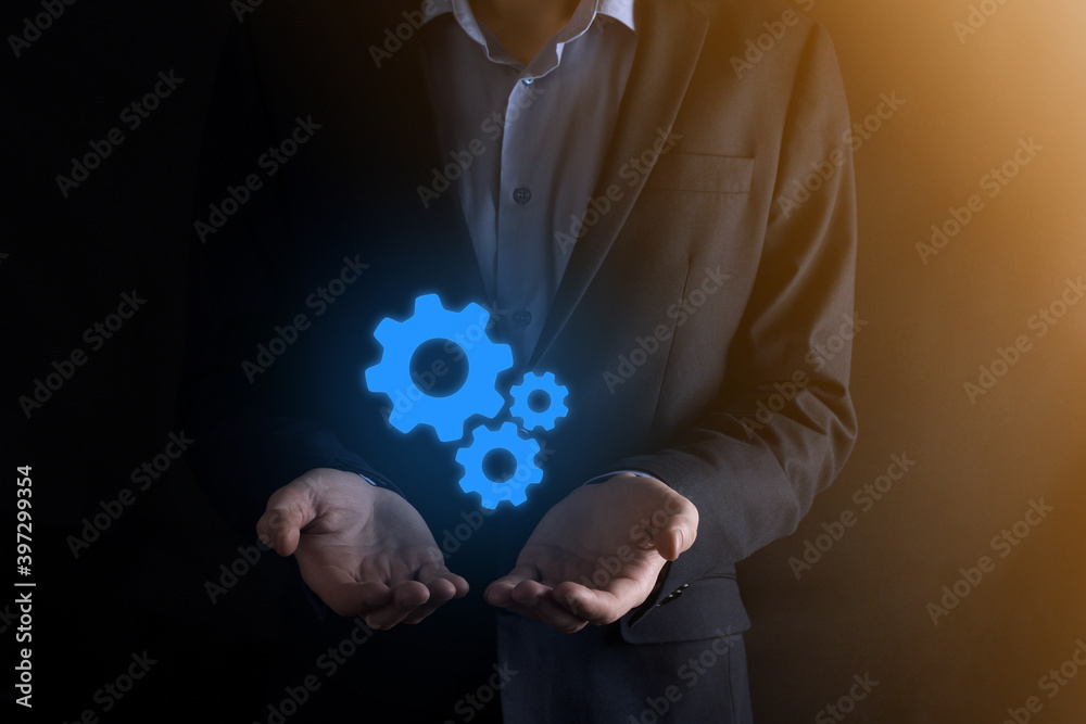 Business man in suit holding metal gears and cogwheels mechanism representing interaction teamwork concept,hand hold group of virtual cog gears wheel Business man in suit holding metal gears and cogwheels mechanism representing interaction teamwork concept,hand hold group of virtual cog gears wheel