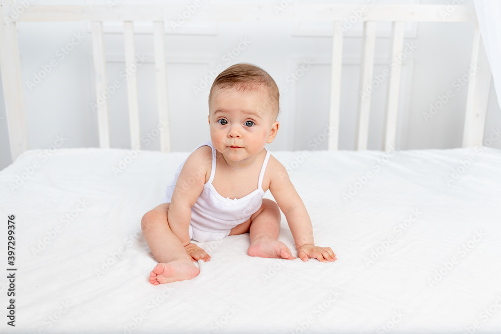 the baby is sitting in a crib in a bright room the baby is sitting in a crib in a bright room