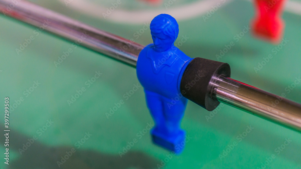 Red and blue table football player on steel rod isolated, GREEN BACKGROUND Red and blue table football player on steel rod isolated, GREEN BACKGROUND