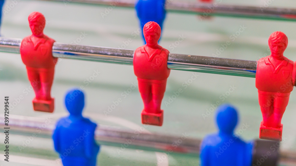 Red and blue table football player on steel rod isolated, GREEN BACKGROUND