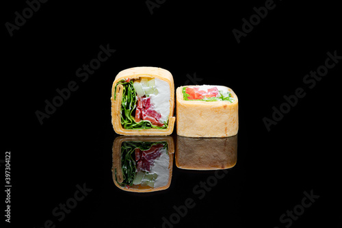 square shaped sushi wrapped in pita bread. on black background