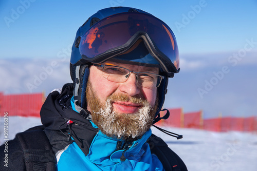adult bearded man in ski suit, helmet and mask