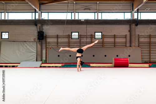 young artistic gymnast woman performing and training somersaults photo