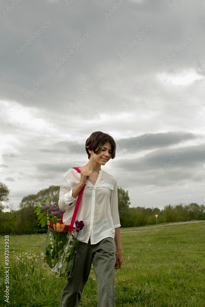 Beautiful girl walking with a plastic transparent bag full of flowers Beautiful girl walking with a plastic transparent bag full of flowers