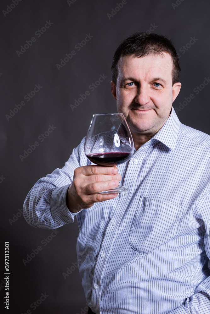 Middle aged cheerful man dressed in a shirt with glass of wine Middle aged cheerful man dressed in a shirt with glass of wine