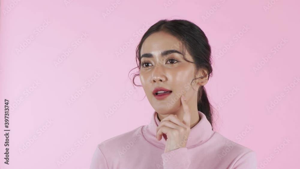 Beauty concept of 4k Resolution. Young Asian woman using brain thinking on a pink background. Beauty concept of 4k Resolution. Young Asian woman using brain thinking on a pink background.