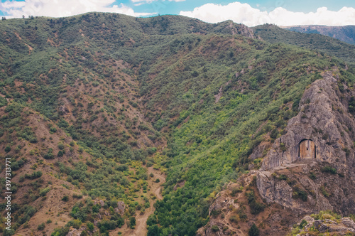 An ancient rock cemetery gate and valley view.