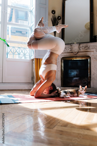 Tranquil woman performing supported headstand on mat photo