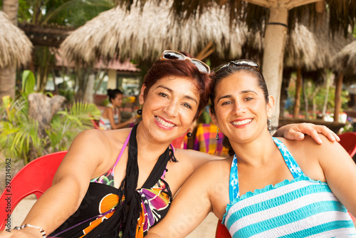 Hispanic women smiling at resort photo