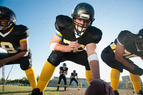 Football players crouching on football field