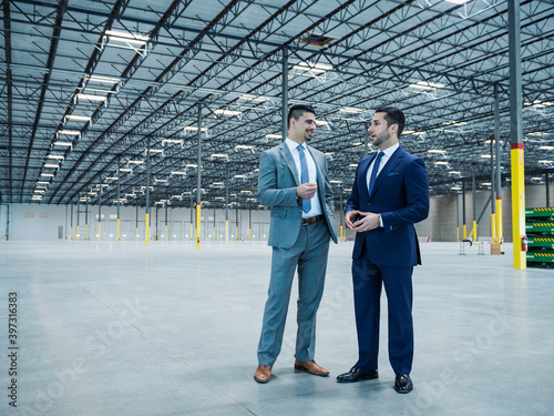 Businessmen talking in empty warehouse photo