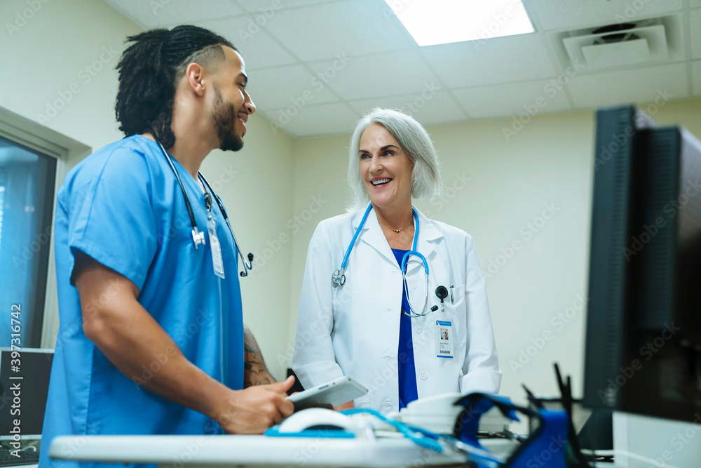 Smiling doctor and nurse talking Smiling doctor and nurse talking