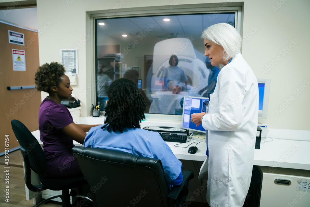 Doctor talking to nurses near scanner Doctor talking to nurses near scanner