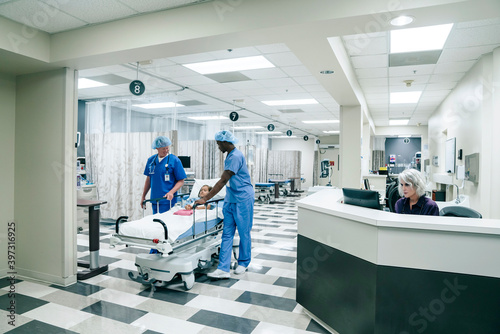 Nurses pushing gurney in hospital photo