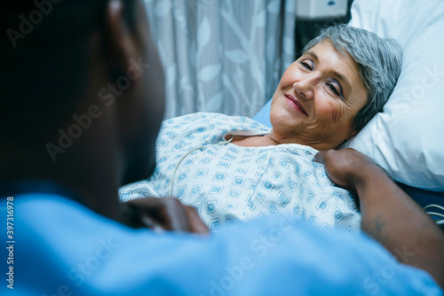 Nurse talking to patient in hospital bed