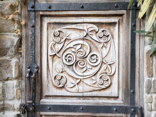 Detail of wood carved door with iron outline