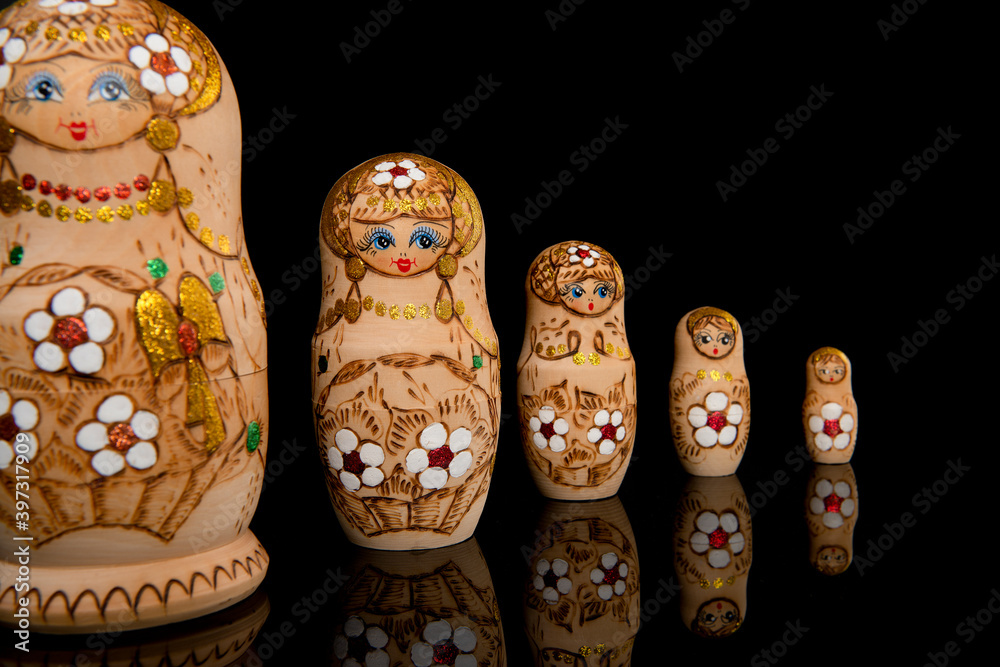 Wooden Russia matrioshka dolls in a row on a blackground